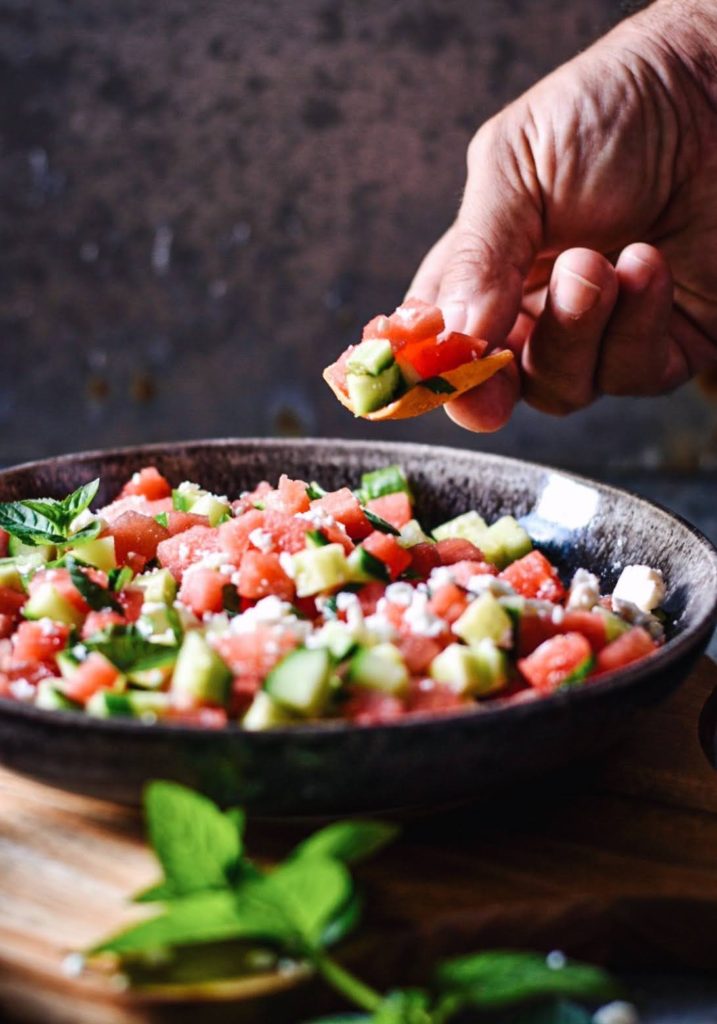 Hand scooping Watermelon salsa.
