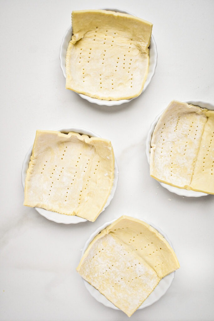 Puff pastry squares laid into white ramekins.