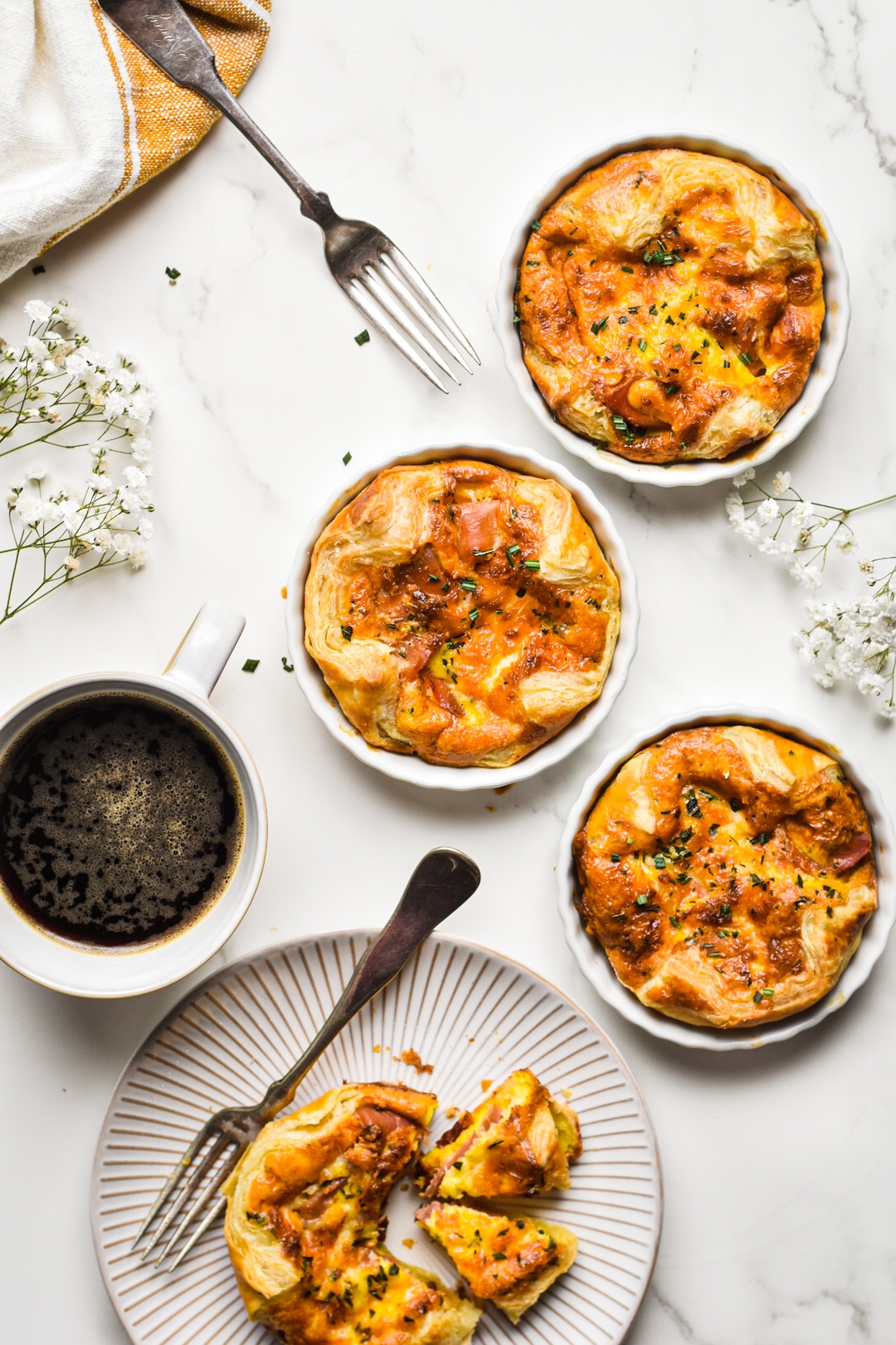Three baked copycat panera souffles in white ramekins with one served on a plate.