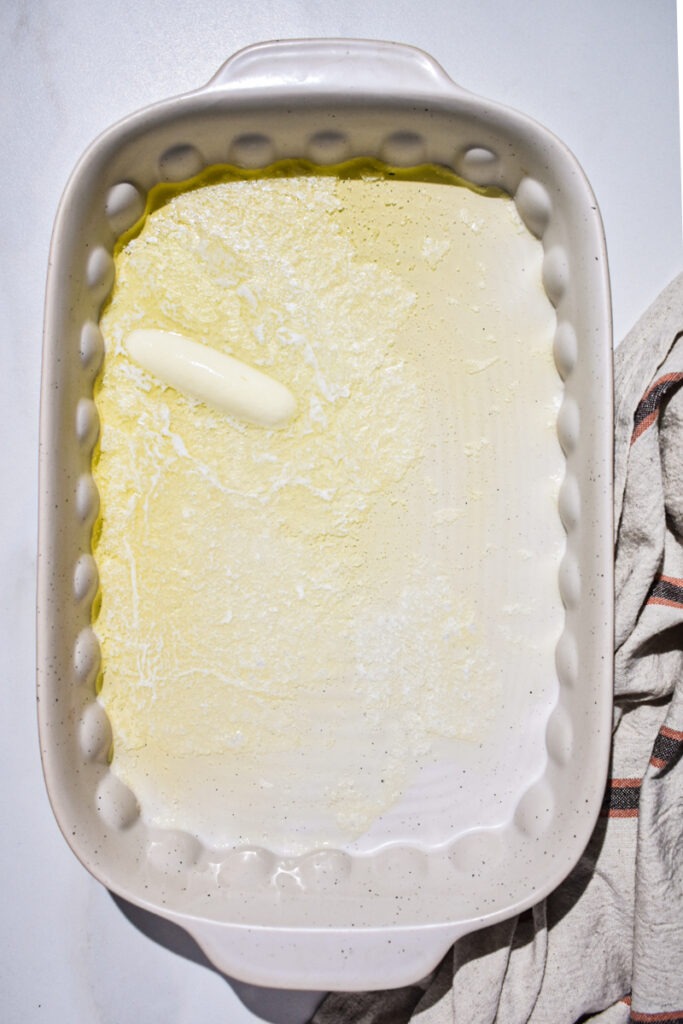Stick of butter melted in a baking dish.