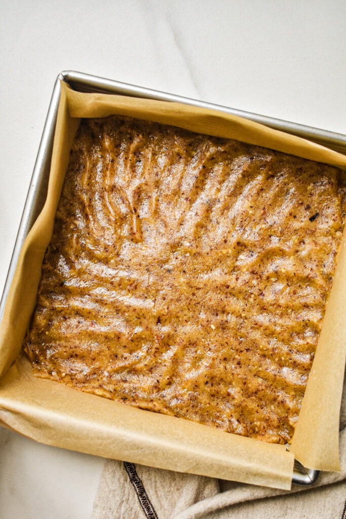 Crust pressed into a parchment-lined square baking pan.