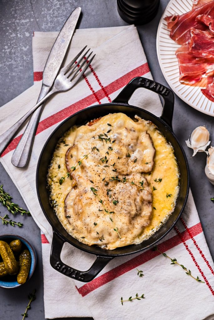 Croûte au fromage (cheesy toast) in a cast iron skillet with thyme on top.