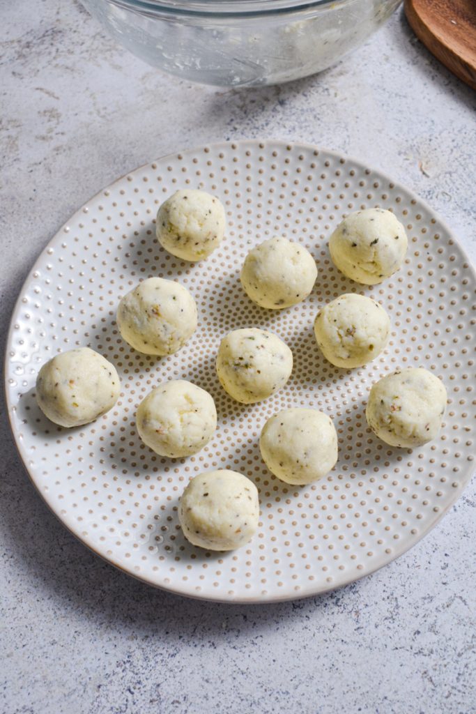 Parmesan balls shaped and placed on a plate to chill.
