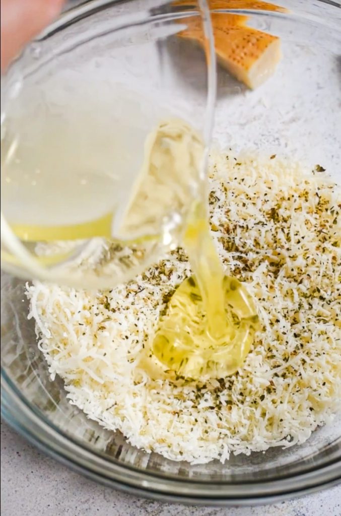 Egg whites being added to the grated parmesan mixture.