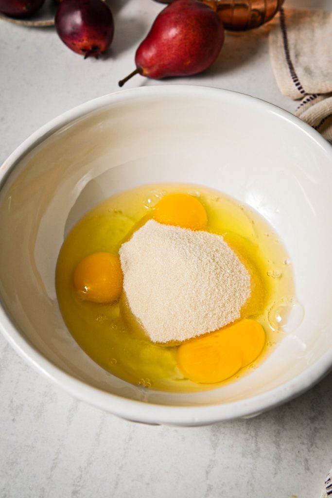Sugar and eggs in a mixing bowl.