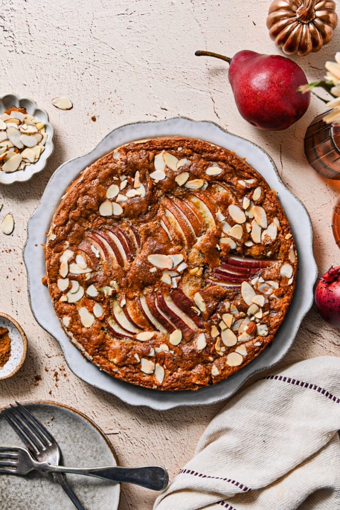 Overhead shot of the baked spicy pear French cake on a large plate.