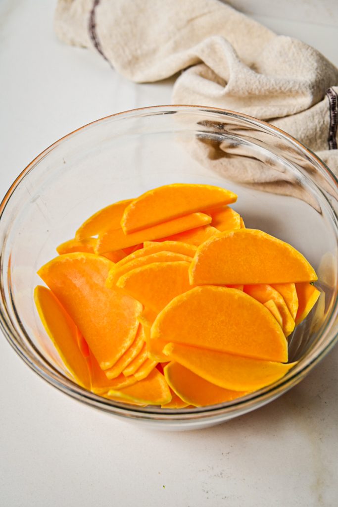 Sliced butternut squash in a mixing bowl.