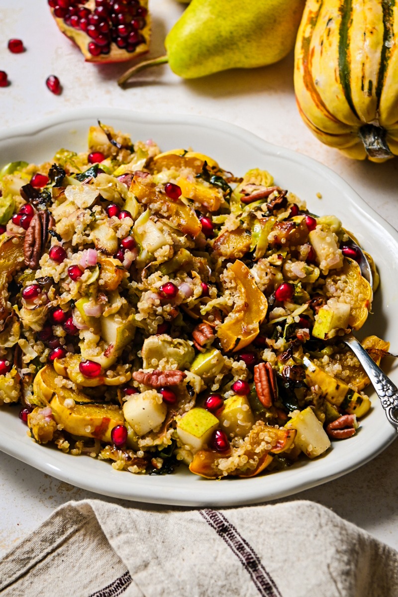 Side view of a fall quinoa salad with delicata squash and brussels sprouts served on a serving dish.