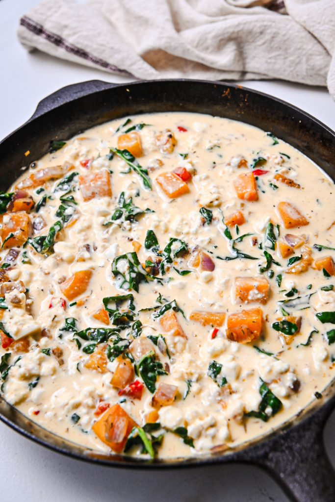 Egg and feta mixture added to the vegetables mixture in the skillet.