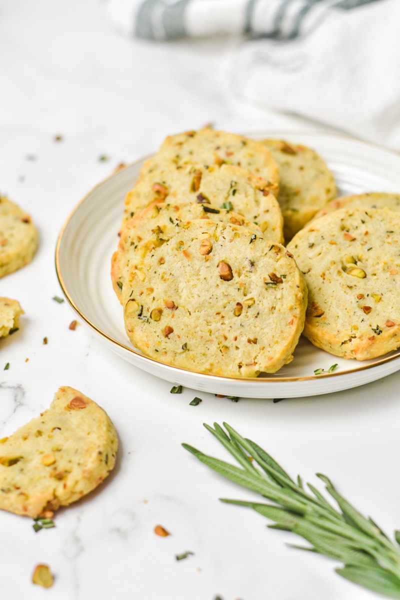 Savory parmesan rosemary shortbread cookies leaning on each other on a plate.