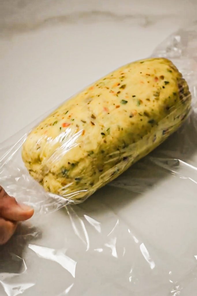 Shortbread dough rolled into a log in a piece of plastic.