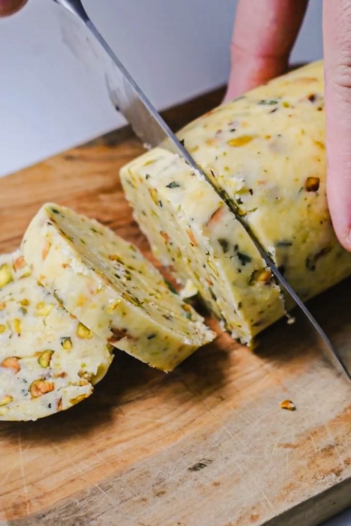 Parmesan rosemary shortbread being sliced into cookies.