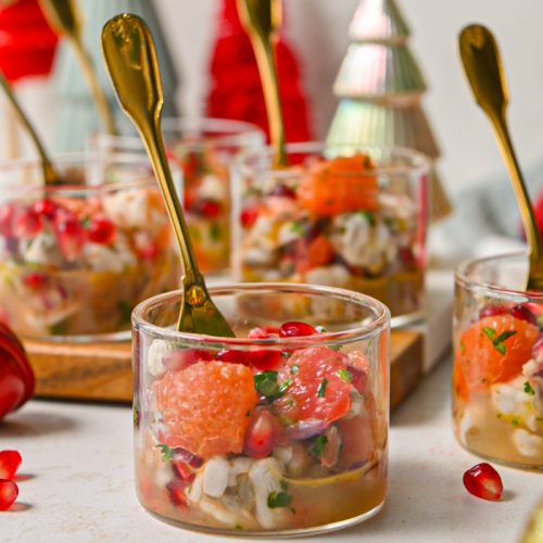 Side view of a glass of winter citrus shrimp ceviche with more glasses around it.