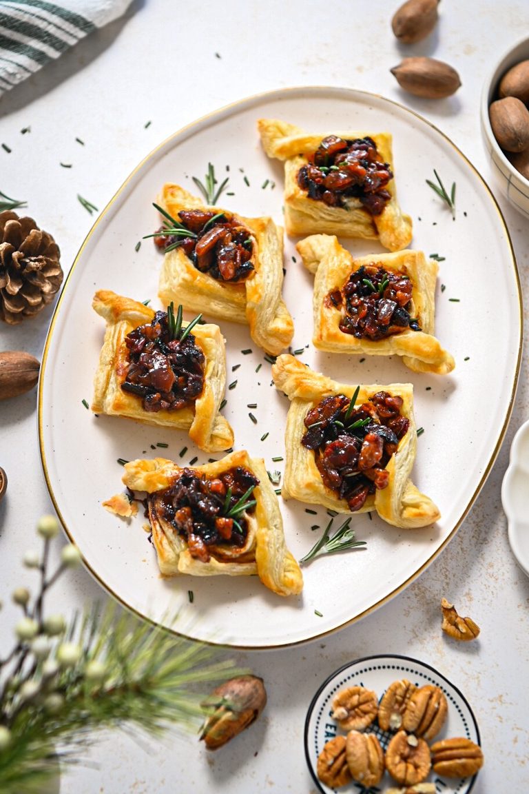 Overhead shot of baked pecan brie bacon jam bites on a white serving platter.
