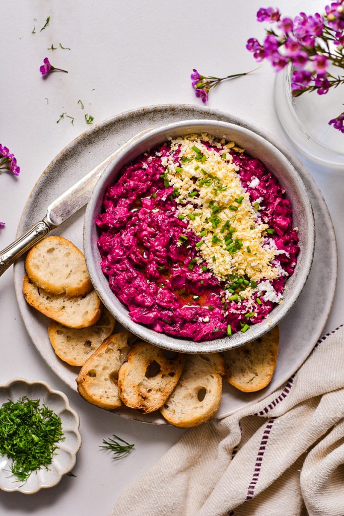 Overhead shot of beetroot and tuna dip in a bowl served with crostini.