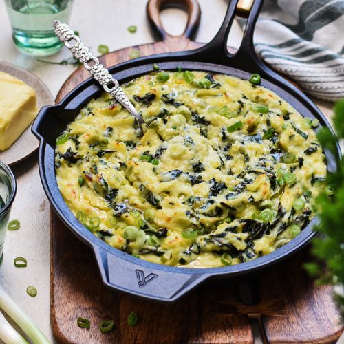 Irish colcannon served in a skillet on a wooden board.