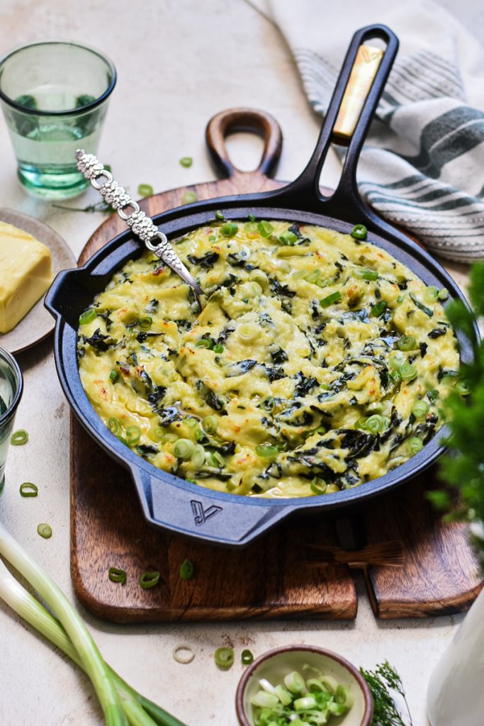 Irish colcannon served in a skillet on a wooden board.