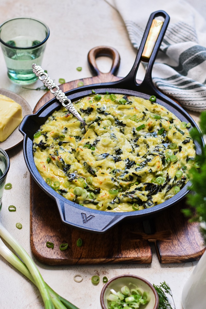 Irish colcannon served in a skillet on a wooden board.
