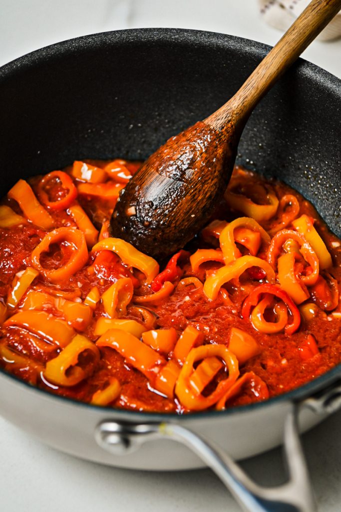 Sweet peppers with tomato paste in a skillet.
