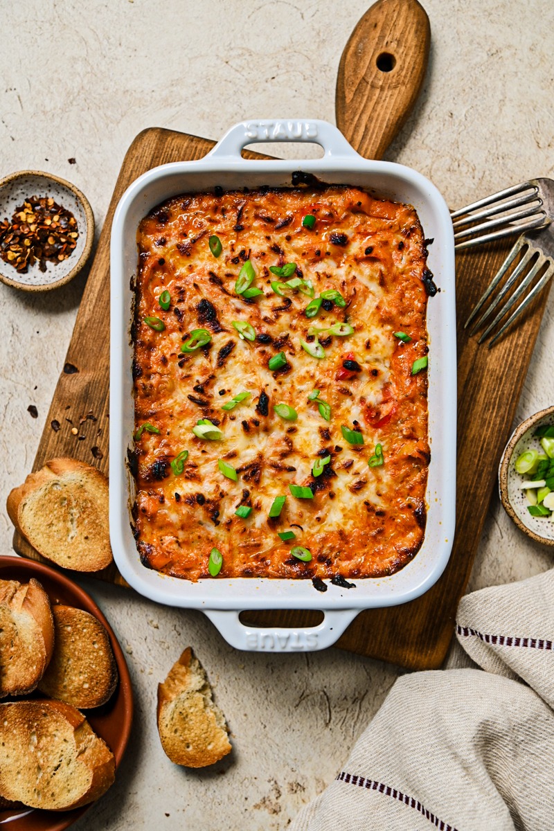 Baked ricotta dip with sweet peppers topped with sliced scallions.