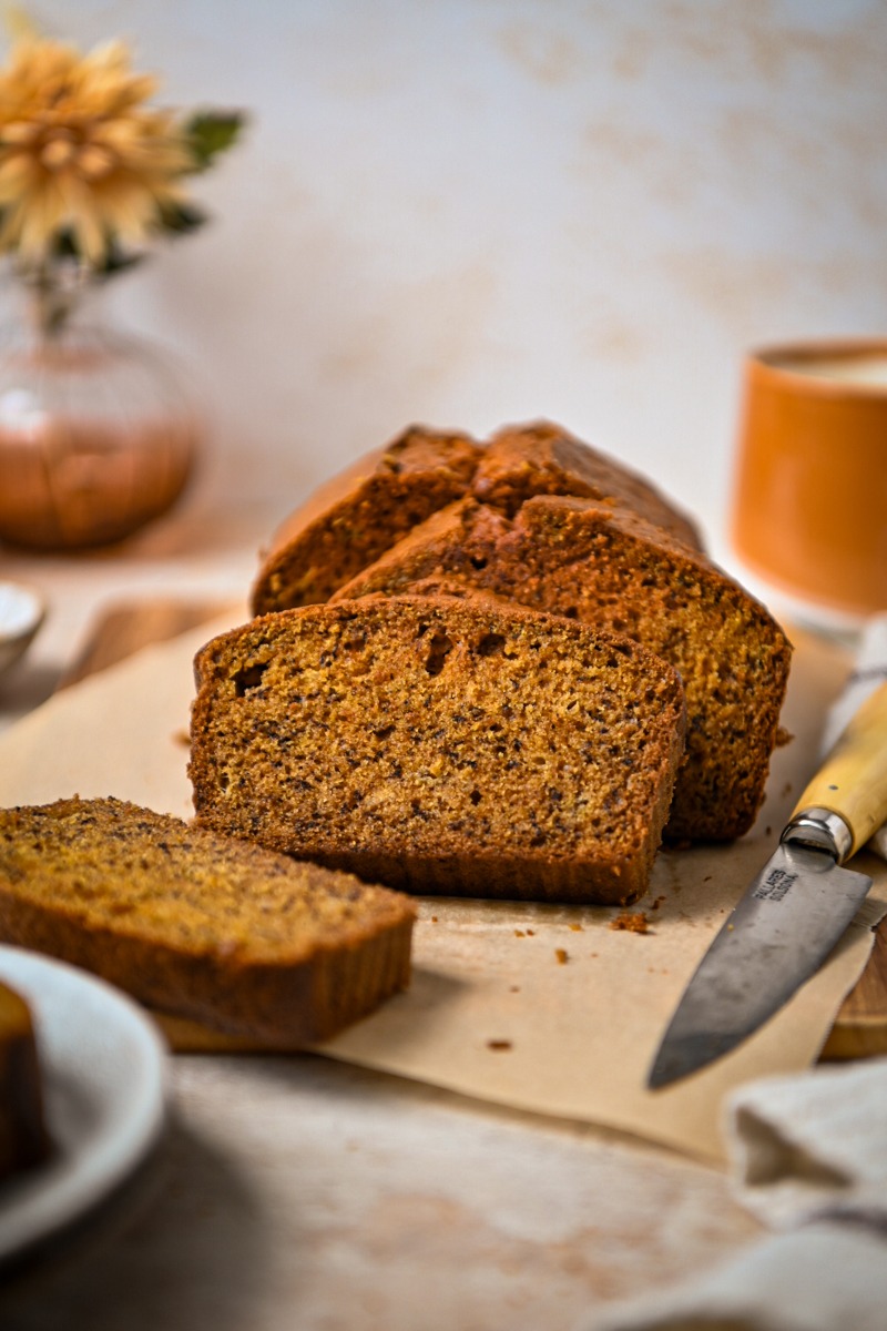 Slices of golden milk banana bread leaning on each other on a board.