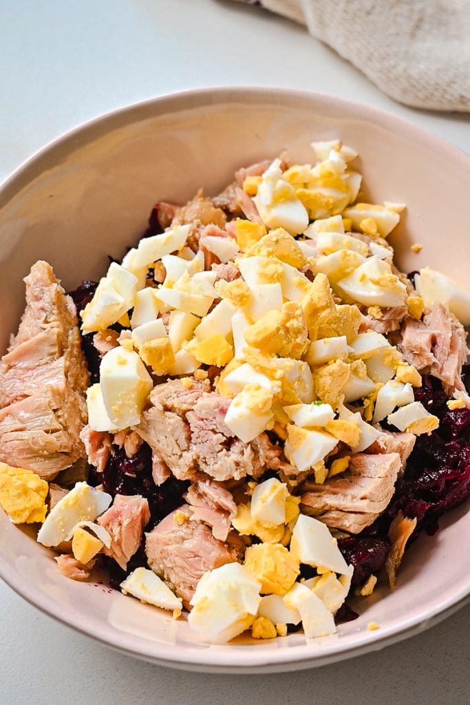 Diced hard boiled egg added to the bowl of tuna and beets.