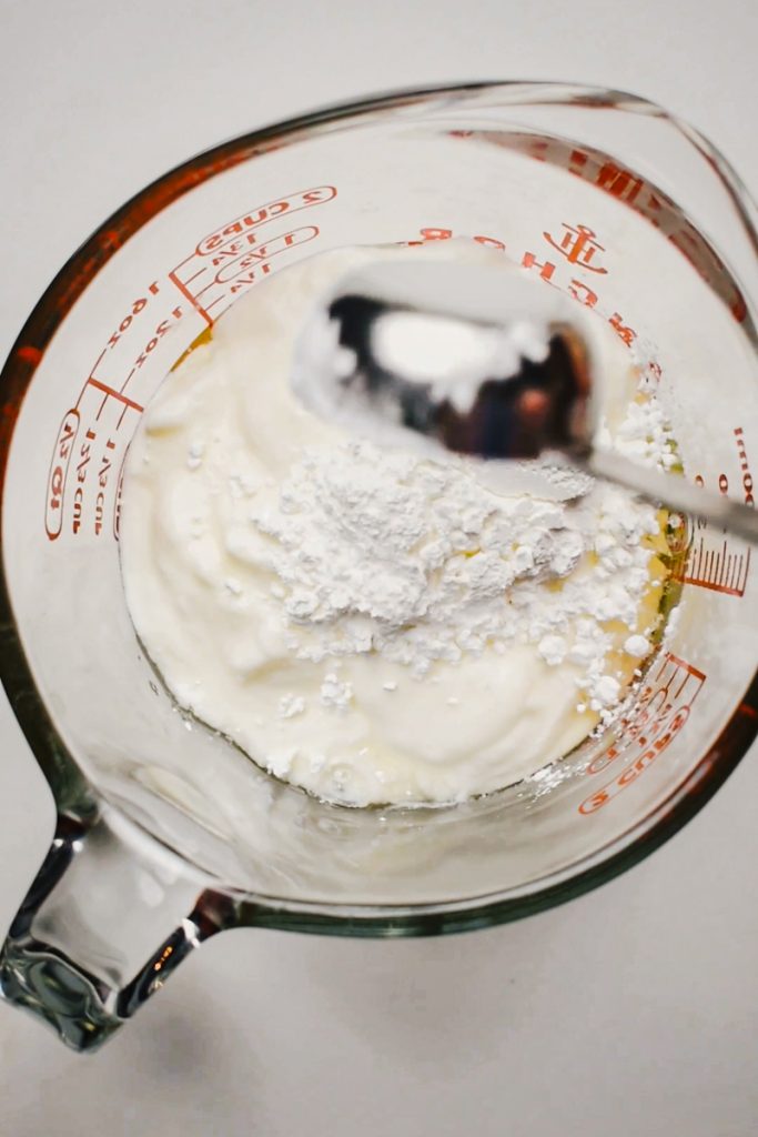 Yogurt and cornstarch in a measuring cup.