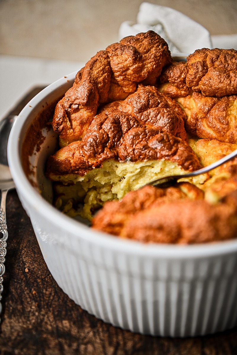 Side view of a cheese souffle in a large baking dish.