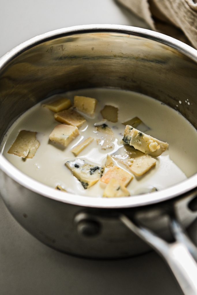 Gorgonzola and heavy cream in a saucepan.