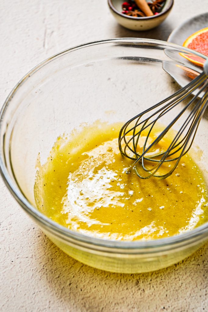Egg yolks, sugar and vanilla whisked together in a glass bowl.