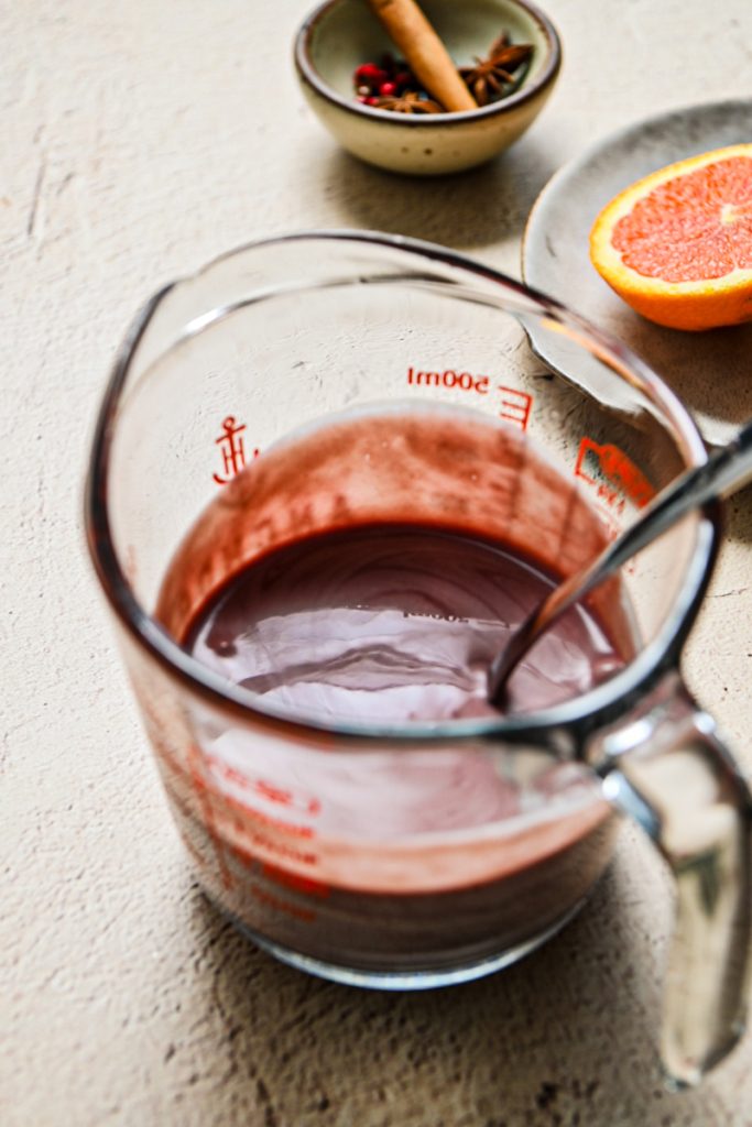 Egg yolk mixture mixed into the warm mulled wine in a measuring cup.