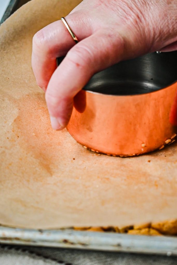 Using a flat bottom measuring cup to smash the chickpeas.
