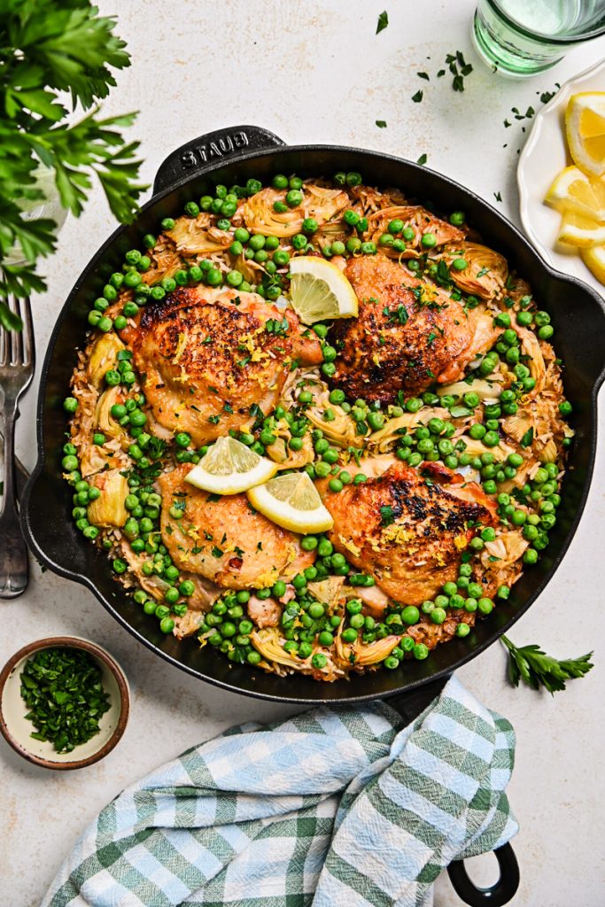 Overhead shot of a lemon chicken skillet with peas and artichokes.