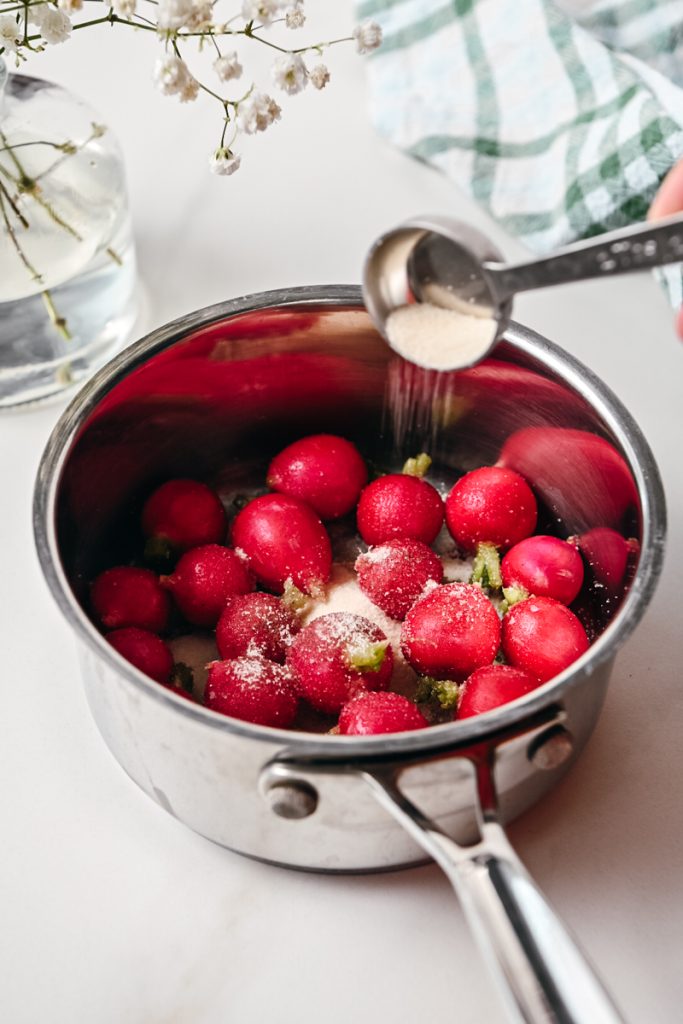 Sugar added to the whole radishes in a sauce pan.