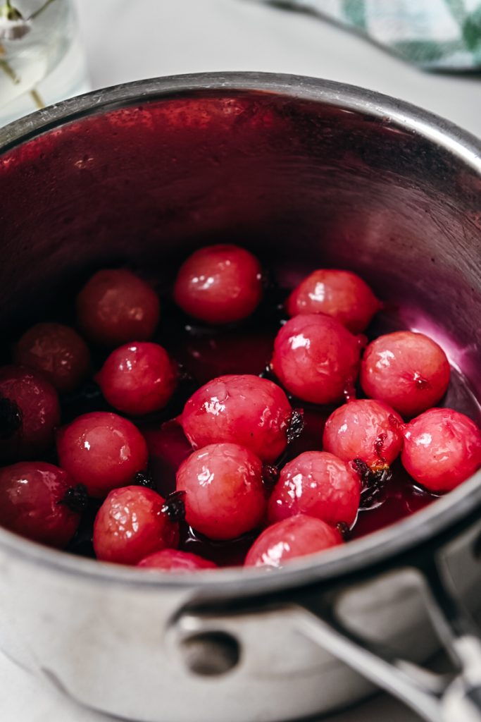 Close up of glazed radishes in a saucepan.