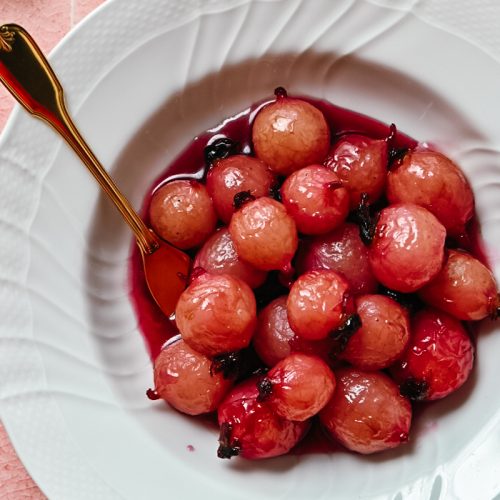 Glazed radishes in a white bowl with a fork.