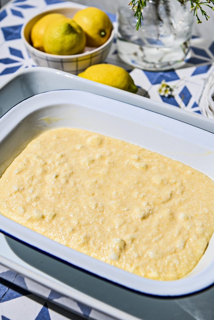 Lemon pudding cake poured into a baking dish and placed into a water bath to bake.