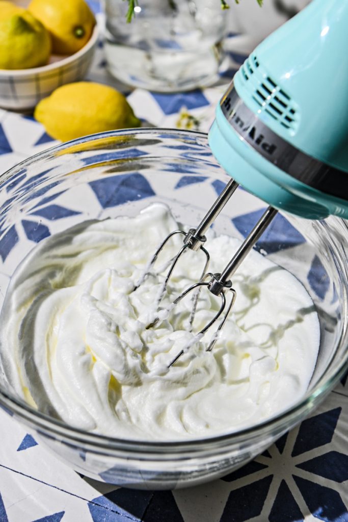 Whipping egg whites in a glass mixing bowl.