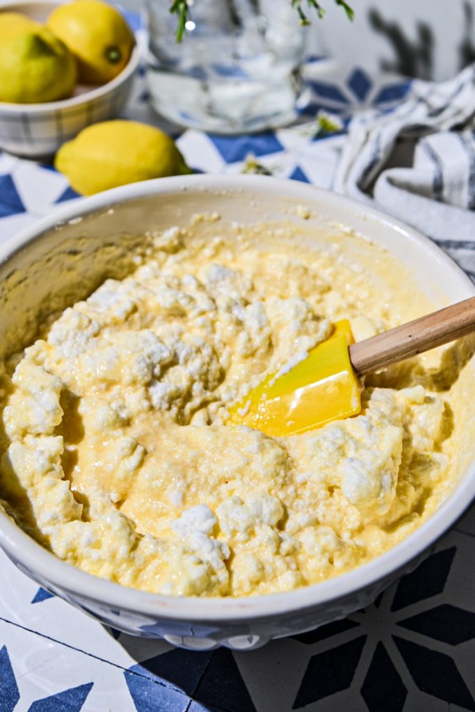 Folding egg whites into the batter in a bowl.