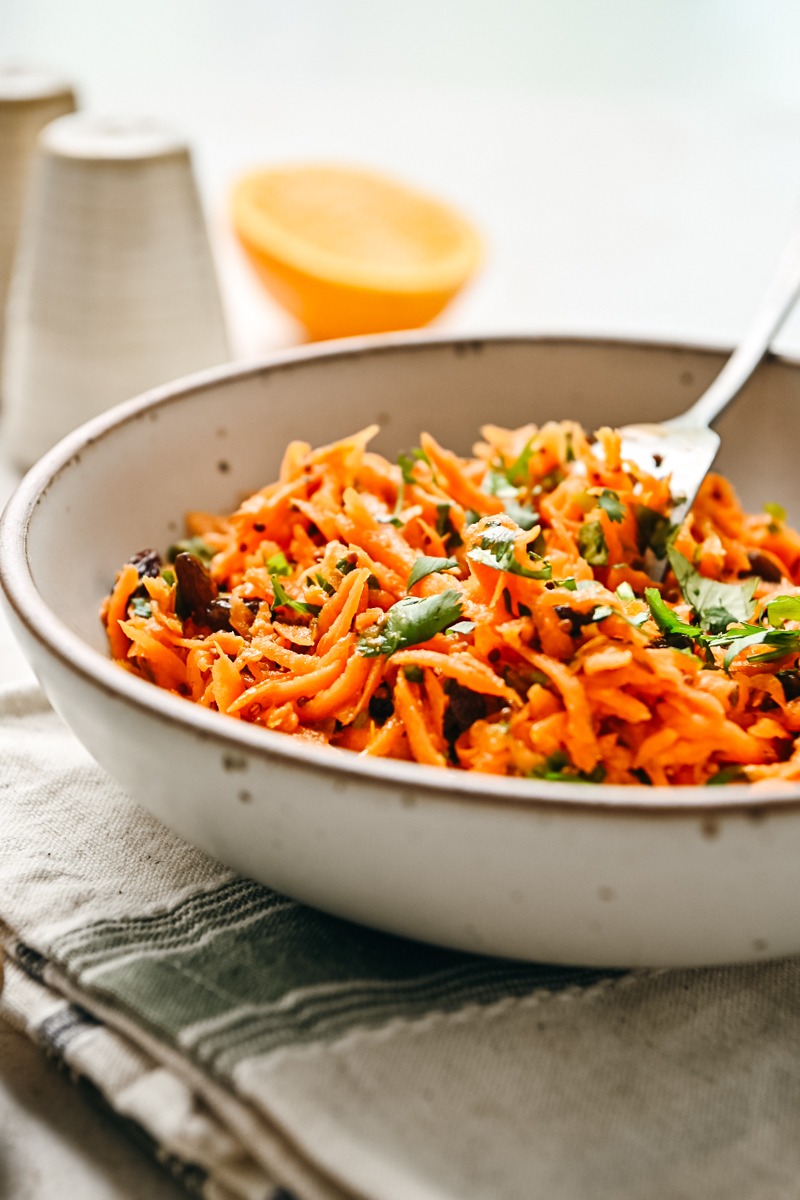 Side view of Moroccan carrot salad in a serving bowl.