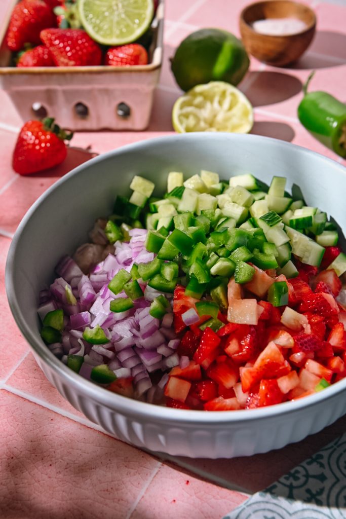 Red onion, strawberries, cucumber and jalapeno added to the bowl of shrimp.