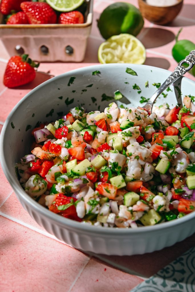 Strawberry shrimp ceviche mixed around in a bowl with a spoon.