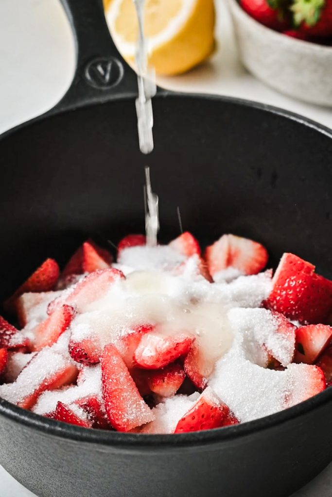 Fresh strawberries with sugar and lemon in a saucepan.