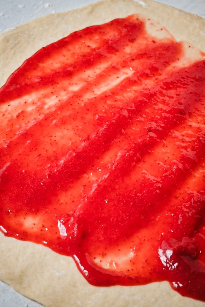 Strawberry compote spread across the prepared dough.