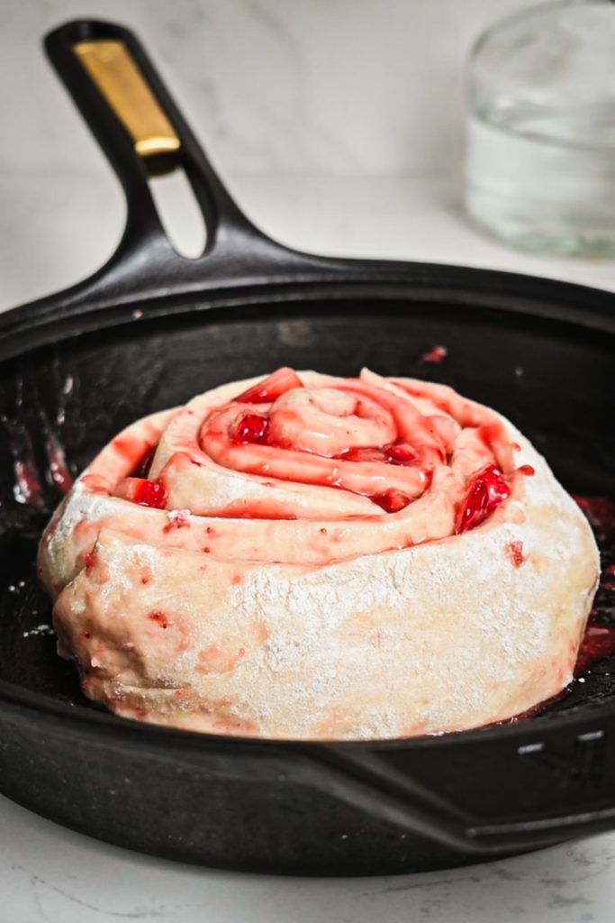 Prepared strawberry roll placed in a skillet to rise again.
