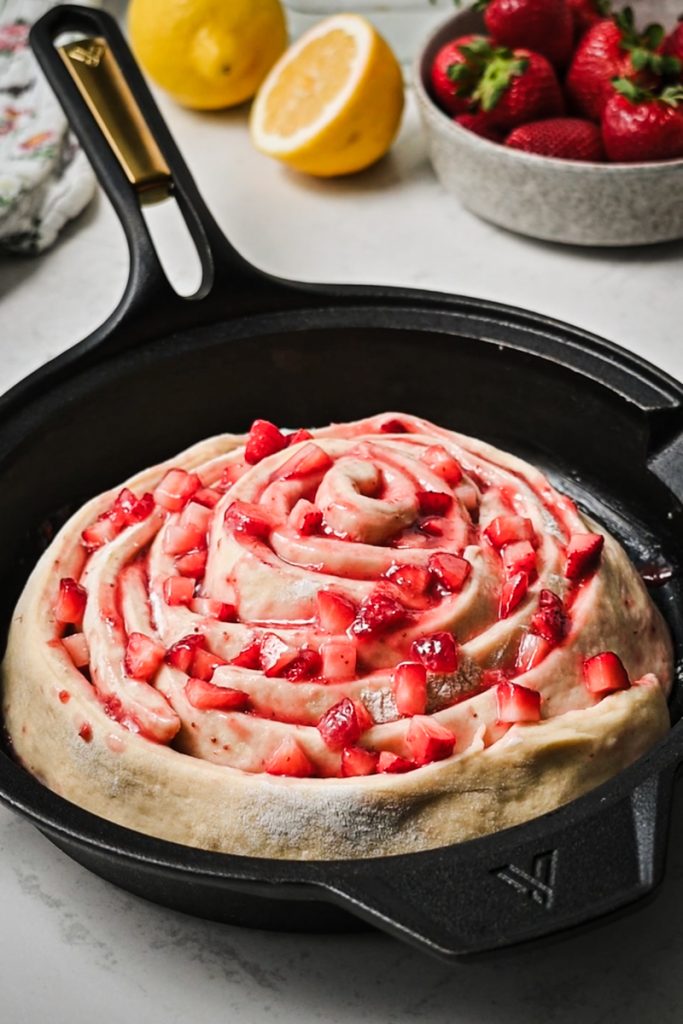 Giant strawberry roll in a skillet after rising the second time.