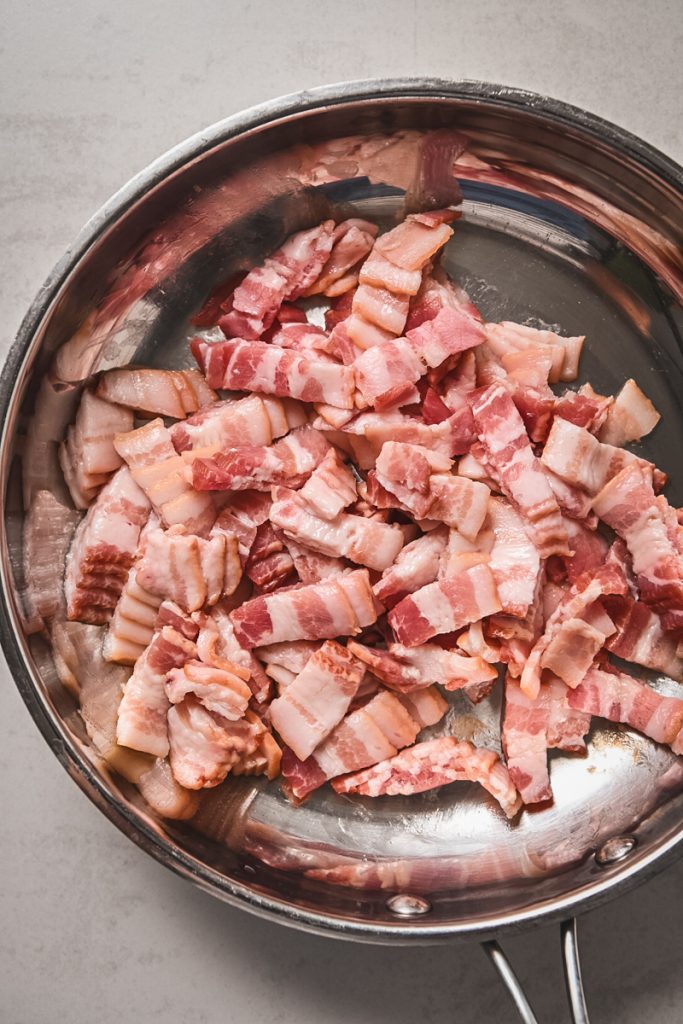 Image of raw bacon in a skillet.