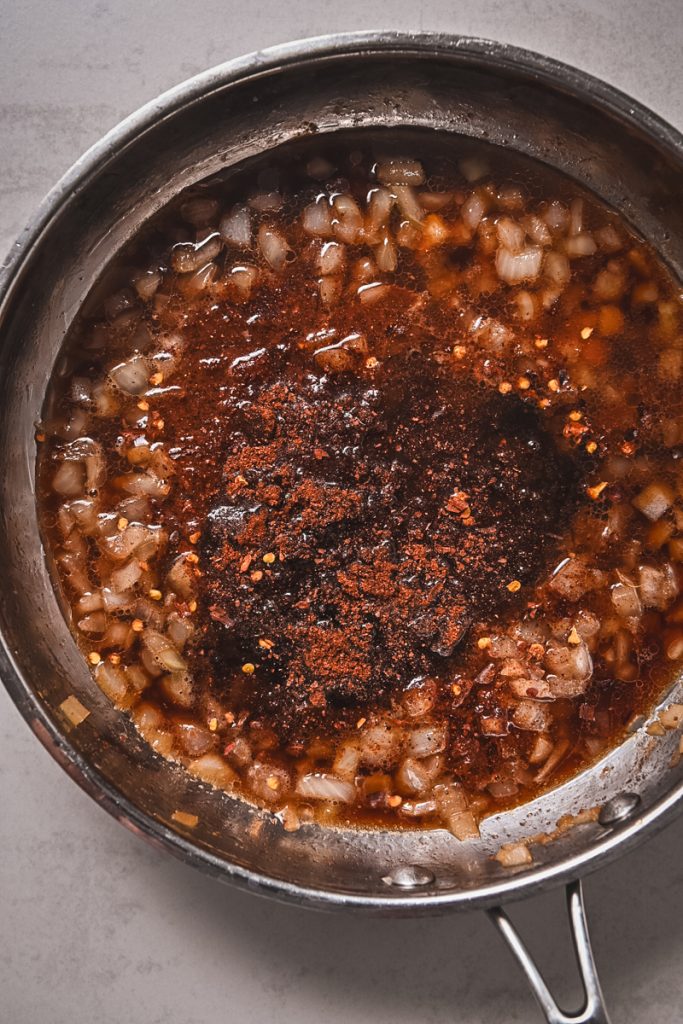 Image of a mixing the onion with spices and bourbon.
