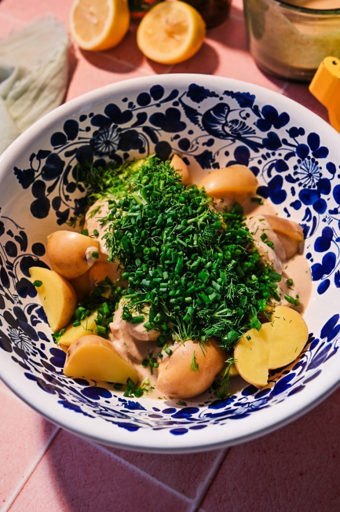 Fresh herbs placed in the tonnato potato salad in a bowl.