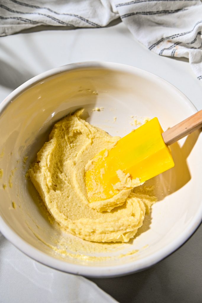 Creamed butter and sugar in a mixing bowl with a spatula.